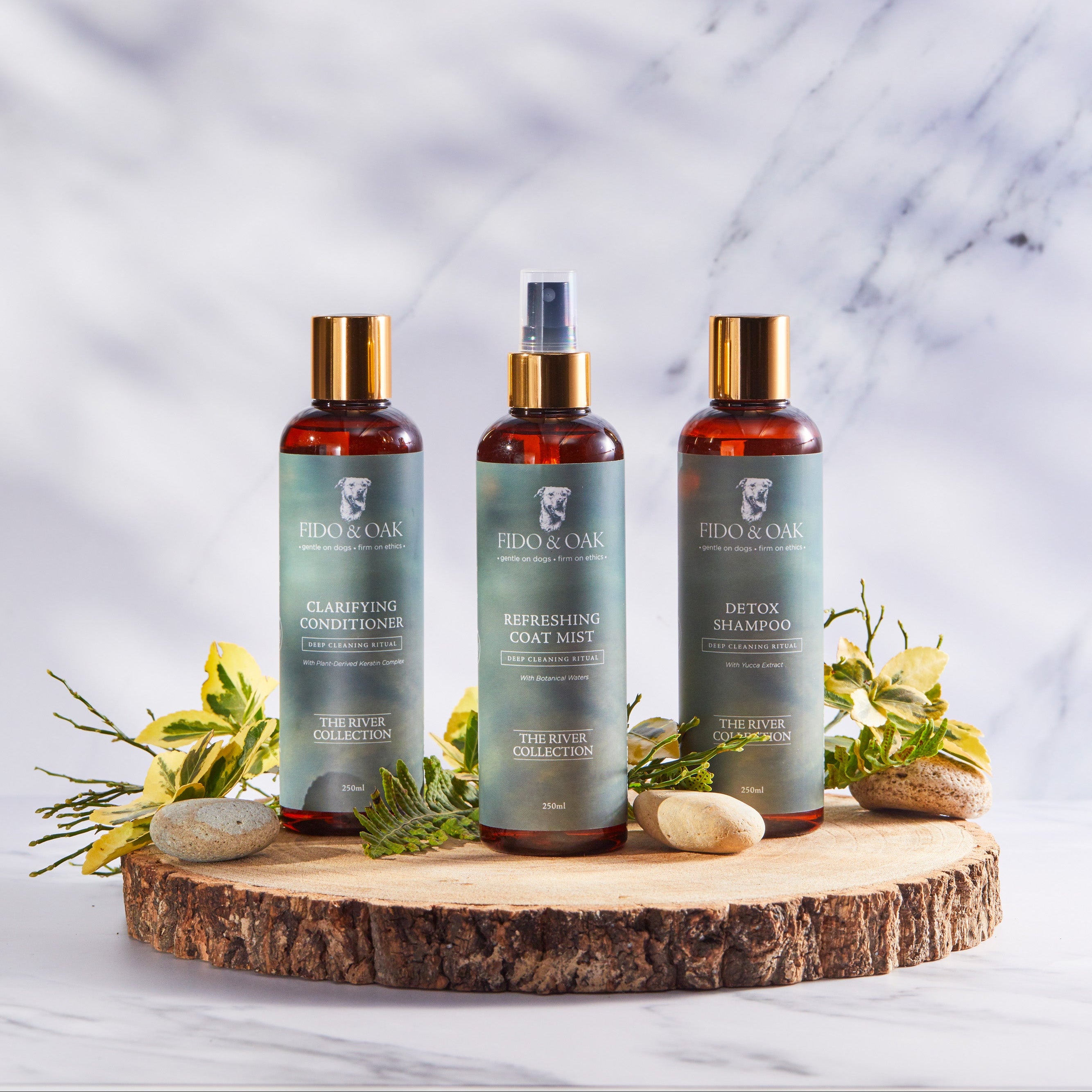 Bottles of Fido & Oak dog shampoo, conditioner, and coat mist with a marble background